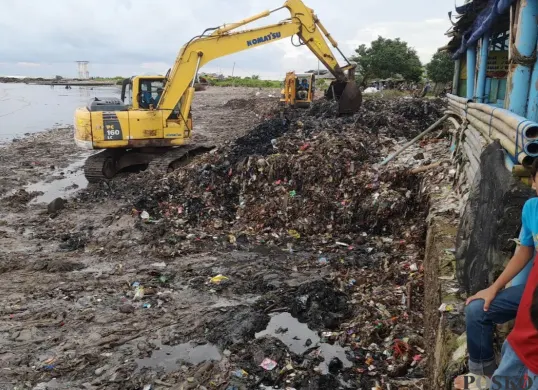Alat berat mengeruk tumpukan sampah di Pantai Teluk, Kecamatan Labuan, Kabupaten Pandeglang, Kamis, 24 April 2025. (Sumber: Poskota/Samsul Fatoni)