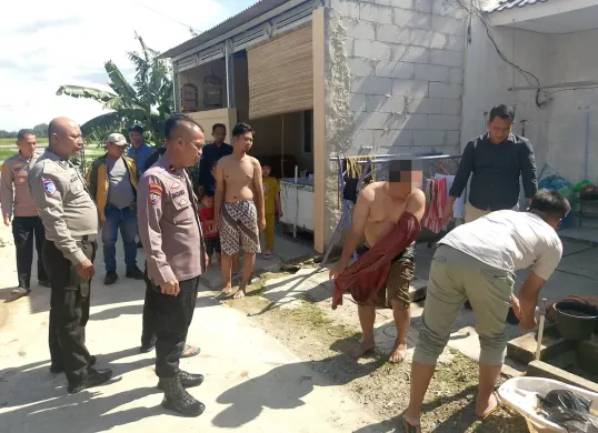 Petugas Polsek Cikande saat mengamankan TM yang berendam dalam rawa karena mengaku diburu bandar narkoba. (Sumber: Dok. Polsek Cikande)