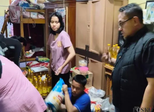 Petugas Polsek Cempaka Putih menggeledah kediaman sindikat pemalsuan voucher sembako rumah sakit. Tiga orang pelaku pasangan suami istri dan adik ipar ditangkap di Cempaka Putih. (Sumber: Poskota/Angga Pahlevi)