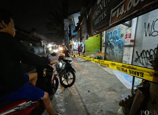 Warga melihat lokasi pembunuhan di Jalan Masjid Darussalam, Kelurahan Kedaung, Pamulang, Tangsel yang telah dipasang garis polisi, Rabu, 30 April 2025. (Sumber: Poskota/Angga Pahlevi)