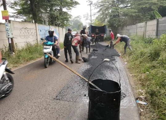 Petugas melakukan perbaikan jalan rusak di sejumlah titik di Kabupaten Bogor. Pemkab Bogor sendiri kini tengah gencar lakukan pemeliharaan jalan. (Sumber: Pemkab Bogor)