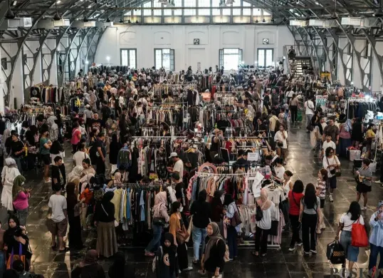 Pengunjung memilih pakaian yang dijual dalam acara Garage Sale di Pos Bloc, Jakarta, Minggu, 3 Agustus 2025. (Sumber: Poskota/Bilal Nugraha Ginanjar)