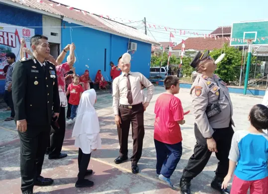 Kapolsek Pancoran Mas AKP Hartono bersama jajaran anggota Polsek ikut lomba makan kerupuk melawan warga RW 03. (Sumber: Polsek Pancoran Mas)
