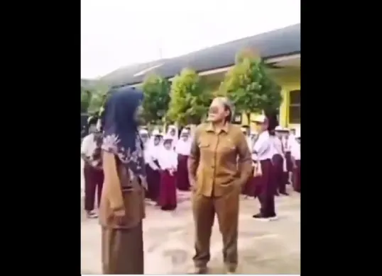 Viral video memperlihatkan guru perempuan berseragam ASN yang diduga melakukan intimidasi terhadap guru lain dan siswa saat upacara bendera di SDN 9 Kedondong, Kabupaten Pesawaran, Lampung. (Sumber: X/@B3doel___)