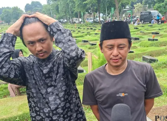 Anak Epy Kusnandar, Kodrat, 37 tahun, dan Damar, 33 tahun, saat pemakaman sang ayah di TPU Jeruk Purut, Cilandak Timur, Pasar Minggu, Jakarta Pusat, Kamis, 4 Desember 2025. (Sumber: Poskota/Angga Pahlevi)