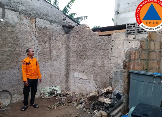 Petugas BPBD Kabupaten Bogor meninjau rumah warga yang terdampak longosran TPT Hotel. (Sumber: BPBD Kabupaten Bogor)