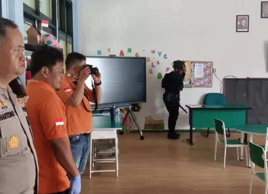 Kapolsek Pancoran Mas AKP Hartono melakukan pendampingan tim Gegana Brimob Kelapa Dua saat menyisir ruangan kelas SMA Arrahman. (Sumber: Humas Polres Metro Depok)