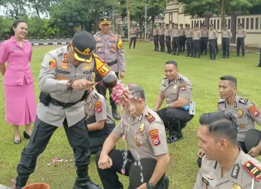 Kapolres Serang, AKBP Condro Sasongko melaksanakan tradisi penyiraman air kembang kepada personel yang naik pangkat, Rabu, 31 Desember 2025. (Sumber: Dok. Polres Serang)
