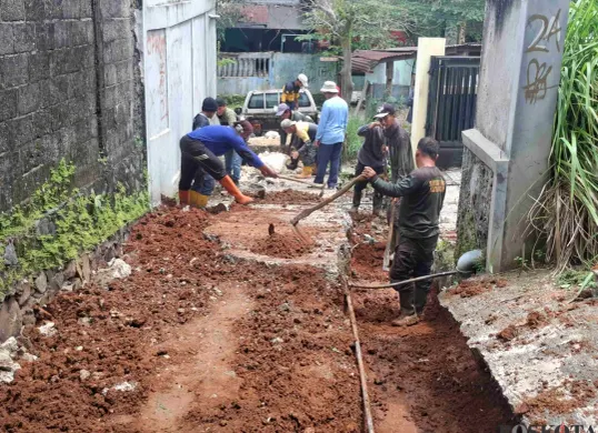 Jalan ambles di lingkungan RT 04 RW 04, Kelurahan Sukmajaya, Kecamatan Sukmajaya, Kota Depok, Jumat 14 Februari 2025, diperbaiki oleh Petugas PUPR Kota Depok. (Sumber: Poskota/Angga Pahlevi)