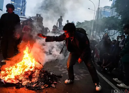 Mahasiswa yang tergabung dalam Badan Eksekutif Mahasiswa Seluruh Indonesia (BEM-SI) membakar spanduk dan ban bekas saat melakukan aksi unjuk rasa di sekitar Patung Arjuna Wijaya, Jakarta, 17 Februari 2025. (Sumber: Poskota/Bilal Nugraha Ginanjar)
