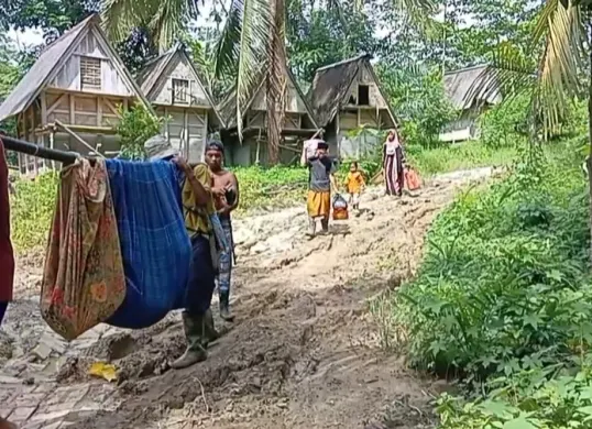 Sejumlah warga di Desa Tanjungan, Kecamatan Cikeusik, Kabupaten Pandeglang, Provinsi Banten menandu pasien ibu hamil yang hendak melahirkan karena kondisi jalan rusak parah. (Sumber: Tangkapan layar video warga)