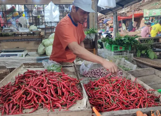 Salah seorang pedagang sembako di pasar badak pandeglang saat menjajakan barang jualannya. (Sumber: Poskota/Samsul Fatoni)