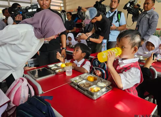 Siswa kelas 1 SDN Lengkong Gudang saat menyantap menu MBG, Senin, 13 Januari 2025. (Sumber: Poskota/Veronica)
