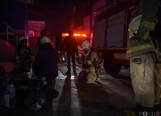 Sejumlah petugas pemadam kebakaran berupaya memadamkan kobaran api sambil mengevakuasi warga yang terjebak dari musibah kebakaran di Glodok Plaza, Tamansari, Jakarta Barat, Rabu 15 Januari 2025. (Sumber: Poskota/Bilal Nugraha Ginanjar)