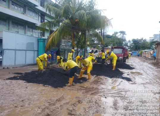 Sejumlah petugas bersiap mengaspal akses jalan menuju SMK 2 Cengkareng, Jakarta Barat, yang rusak dan berlumpur. (Sumber: Instagram/@jakartabarat24jam)