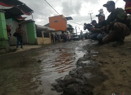 Warga Desa Wangunharja, Kecamatan Lembang, Kabupaten Bandung Barat memancing di tengah jalan yang tergenang air sebagai aksi protes akibat jalan rusak. (Sumber: Poskota/Gatot Poedji Utomo)