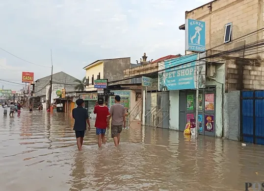 Jalan Raya Pisangan, Desa Satria Mekar, Kecamatan Tambun Utara, Kabupaten Bekasi, lumpuh total usai terendam banjir setinggi 50 sentimeter, Selasa, 8 Juli 2025. (Sumber: Poskota/Nurpini Aulia Rapika)