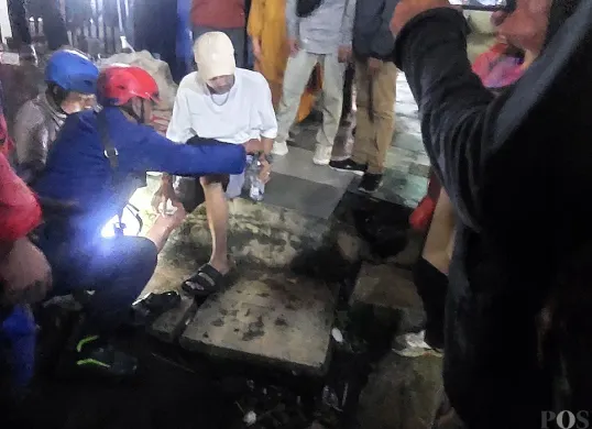 Petugas Damkar Kota Bogor mengevakuasi warga yang kakinya terjepit di rel kereta Stasiun Bogor, Minggu malam, 13 Juli 2025. (Sumber: POSKOTA | Foto: Sekar Putri Andini)