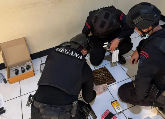 Detasemen Gegana Brimob Mabes Polri memeriksa senjata dan peluru dari koper WNA FIlipina yang menggemparkan warga Pasar Minggu, Jakarta Selatan. (Sumber: Polsek Pasar Minggu)