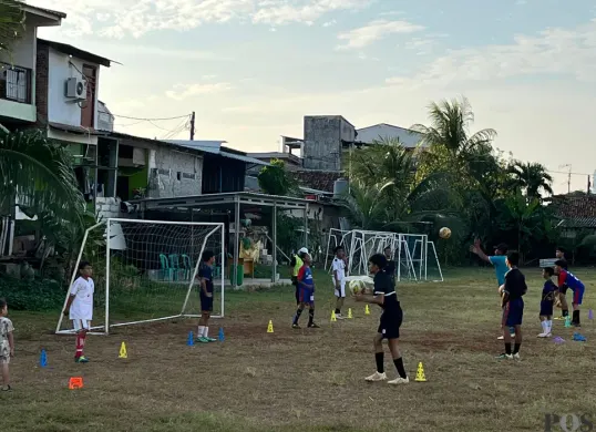 Sejumlah anak dan remaja sedang bermain sepak bola di lapangan dekat Mapolsek Palmerah, Jakarta Barat. (Sumber: POSKOTA | Foto: Pandi Ramedhan)