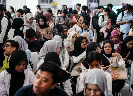 Pencari kerja melihat lowongan pekerjaan di salah satu stan perusahaan di GOR Kemayoran, Jakarta, Selasa, 6 Mei 2025. (Sumber: Poskota/Bilal Nugraha Ginanjar)