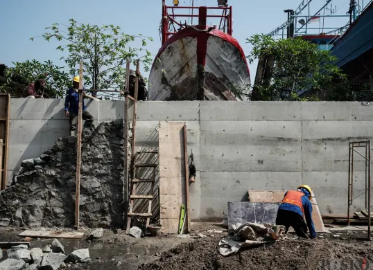 Pekerja menyelesaikan pembangunan tanggul mitigasi di area Docking Kapal Baywalk, Pluit, Jakarta, Kamis, 12 Juni 2025. (Sumber: Poskota/Bilal Nugraha Ginanjar)