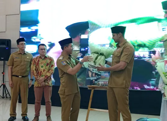 Bupati Bandung Dadang Supriatna menyerahkan buku Aksara Swara kepada Wakil Bupati Bandung Ali Syakieb. (Sumber: Dok. Pemkab Bandung)