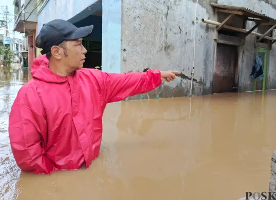 Warga menunjuk lokasi banjir di wilayah Pejaten Timur yang ketinggiannya sudah merendam rumah lantai dua, Selasa, 4 Maret 2025. (Sumber: Poskota/Ali Mansur)