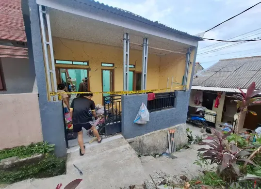 Aparat kepolisian memasangi garis polisi di sekitar rumah yang menjadi TKP ledakan tabung gas LPG 3 kg di Depok. (Sumber: Poskota/Angga Pahlevi)