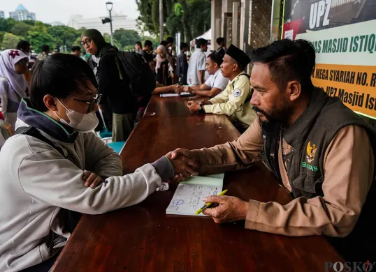Petugas melayani sejumlah jamaah saat proses pembayaran zakat fitrah di Masjid Istiqlal, Jakarta, Senin, 24 Maret 2025. (Sumber: Poskota/Bilal Nugraha Ginanjar)