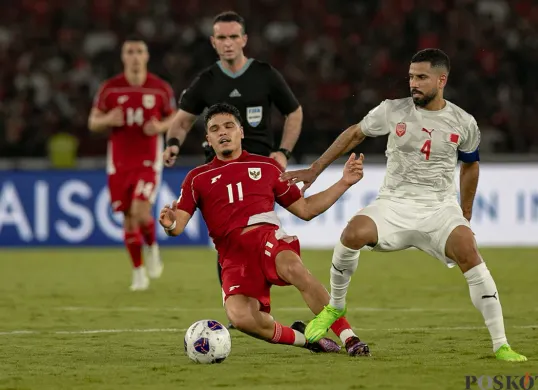 Pemain Timnas Indonesia, Ragnar Oratmangoen (11) saat dijegal pemian Bahrain, Sayed Dhiya Saeed (4). (Sumber: Poskota/Bilal Nugraha Ginanjar)