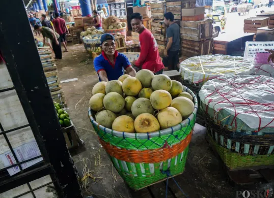 Pedagang mendorong wadah berisi buah timun suri di Pasar Induk Kramat Jati, Jakarta Timur, Senin (10/3). (Sumber: Poskota/Bilal Nugraha Ginanjar)