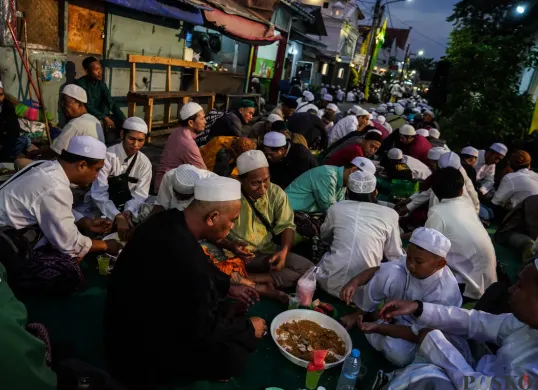 Warga buka puasa bersama di lingkungan sekitar Masjid Azzawiyah dan Masjid Jami' Annawier, di kampung Arab, Pekojan, Jakarta Barat, Rabu, 26 Maret 2025. (Sumber: Poskota/Bilal Nugraha Ginanjar)