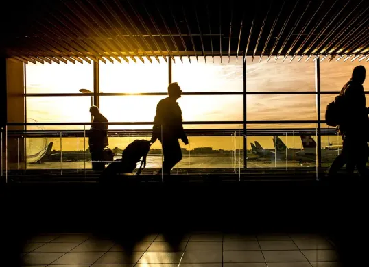 Siluet di bandara saat matahari terbenam. Nikmati liburan bebas repot di Surabaya dengan layanan antar jemput bandara yang nyaman, aman dan praktis. (Sumber: Pixabay/ClickerHappy)