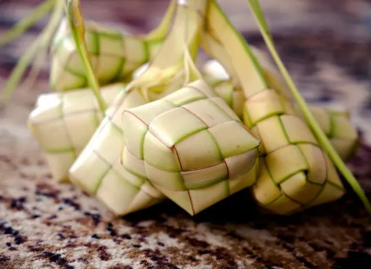 Terbuat dari daun kelapa muda (janur), ketupat merupakan simbol khas dalam tradisi kuliner Indonesia, khususnya saat perayaan Idulfitri. Hidangan ini biasanya diisi dengan beras dan direbus hingga matang. (Sumber: Pixabay/ignartonosbg)