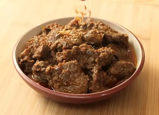 Taburan bawang goreng membuat Rendang Jawa, semakin lezat. Hidangan ini dibuat dengan daging sapi yang dimasak perlahan dalam campuran santan, bumbu, dan rempah-rempah. (Sumber: YouTube/Devina Hermawan)