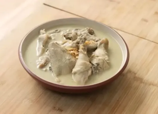 Tangkapan layar hidangan opor ayam putih dengan kuah santan yang gurih dan lezat, cocok disajikan sebagai hidangan khas saat Lebaran atau acara keluarga. (Sumber: YouTube/Devina Hermawan)
