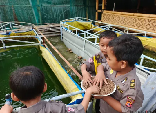 Anak-anak di sekolah alam terlihat gembira saat belajar di luar. Mereka bisa berinteraksi langsung dengan tanaman, ikan, hingga hewan ternak. (Sumber: Poskota/Nurpini Aulia Rapika)
