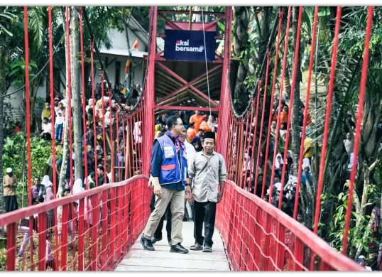 Potret Anies Baswedan yang berdiri di atas jembatan 'Titian Persatuan' yang dibangun melalui organisasi Aksi Bersama. (Sumber: X/@aniesbaswedan)