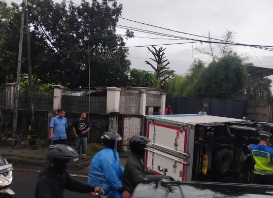 Petugas Unit Laka Lantas Polres Metro Depok mengevakuasi truk yang terguling di Jalan Raya Bojongsari - Ciputat, Senin, 26 Mei 2025, pagi. (Sumber: Polres Metro Depok)