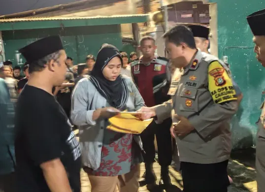 Kapolsek Cakung Kompol Widodo Saputro  didampingi wakapolsek memberikan santunan kepada korban hansip yang tewas ditembak pencuri motor. (Sumber: Istimewa)