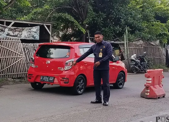 Petugas keamanan kompleks menunjukkan TKP aksi perampokan di Jalan Raya Nonon Sonthanie, Bekasi Timur, Kota Bekasi. (Sumber: POSKOTA | Foto: Nurpini Aulia Rapika)