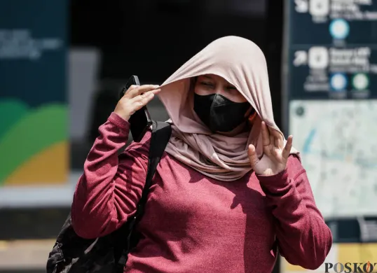 Warga berjalan di tengah cuaca terik di Jalan Jenderal Sudirman, Jakarta. (Sumber: Poskota/Bilal Nugraha Ginanjar)