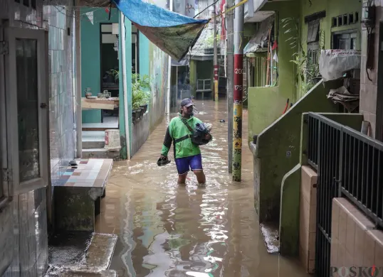 Warga berjalan melintasi banjir di Kebon Pala, Jatinegara, Jakarta Timur, Selasa, 28 Oktober 2025. (Sumber: Poskota/Bilal Nugraha Ginanjar)