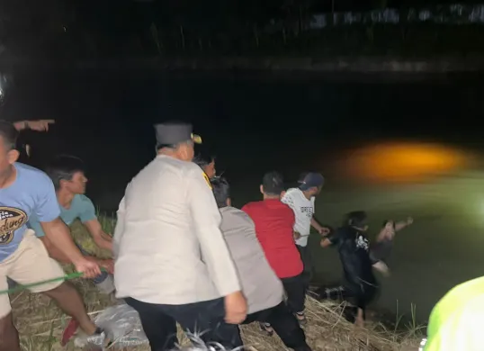 Petugas Polsek Kragilan dibantu masyarakat mengevakuasi kendaraan dari dalam sungai irigasi. (Sumber: Polres Serang)