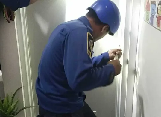 Petugas Damkar Kabupaten Bogor mencoba membuka pintu kamar mandi yang terkunci, untuk mengevakuasi pelajar yang terjebak. (Sumber: Damkar)