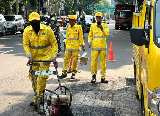 Pasukan Kuning Dinas Bina Marga saat memperbaiki jalan di Kebon Sirih, Jakarta Pusat, Selasa, 14 April 2026. (Sumber: Poskota/M Tegar Jihad)