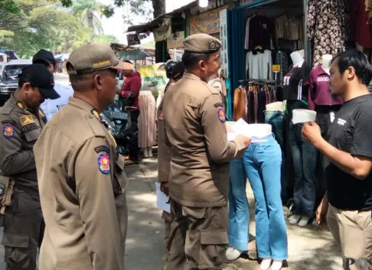 Satpol PP Kabupaten Tangerang mendistribusikan surat peringatan pertama kepada pemilik bangunan liar di wilayah Desa Sukamantri, Kecamatan Pasar Kemis, Kamis, 23 April 2026. (Sumber: Poskota/Veronica Prasetio)