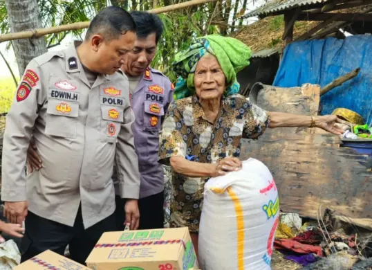 Petugas Polsek Ciruas memberikan bantuan sembako kepada korban kebakaran rumah di Kampung Kesampangan, Desa Cigelam, Kecamatan Ciruas, Kabupaten Serang. (Sumber: Dok. Istimewa)