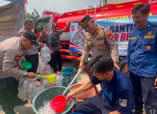 Anggota Polresta Tangerang saat menyalurkan air bersih kepada masyarakat di Kecamatan Tigaraksa. (Sumber: Poskota/Veronica)